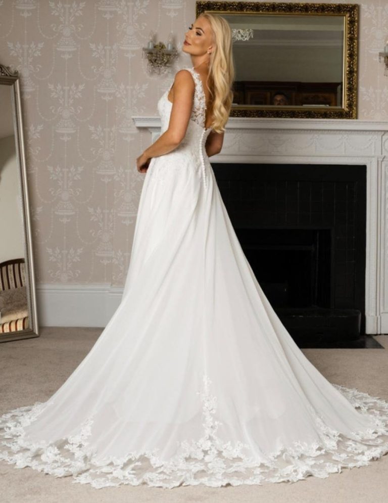 A woman in a flowing white wedding dress with delicate lace detailing.